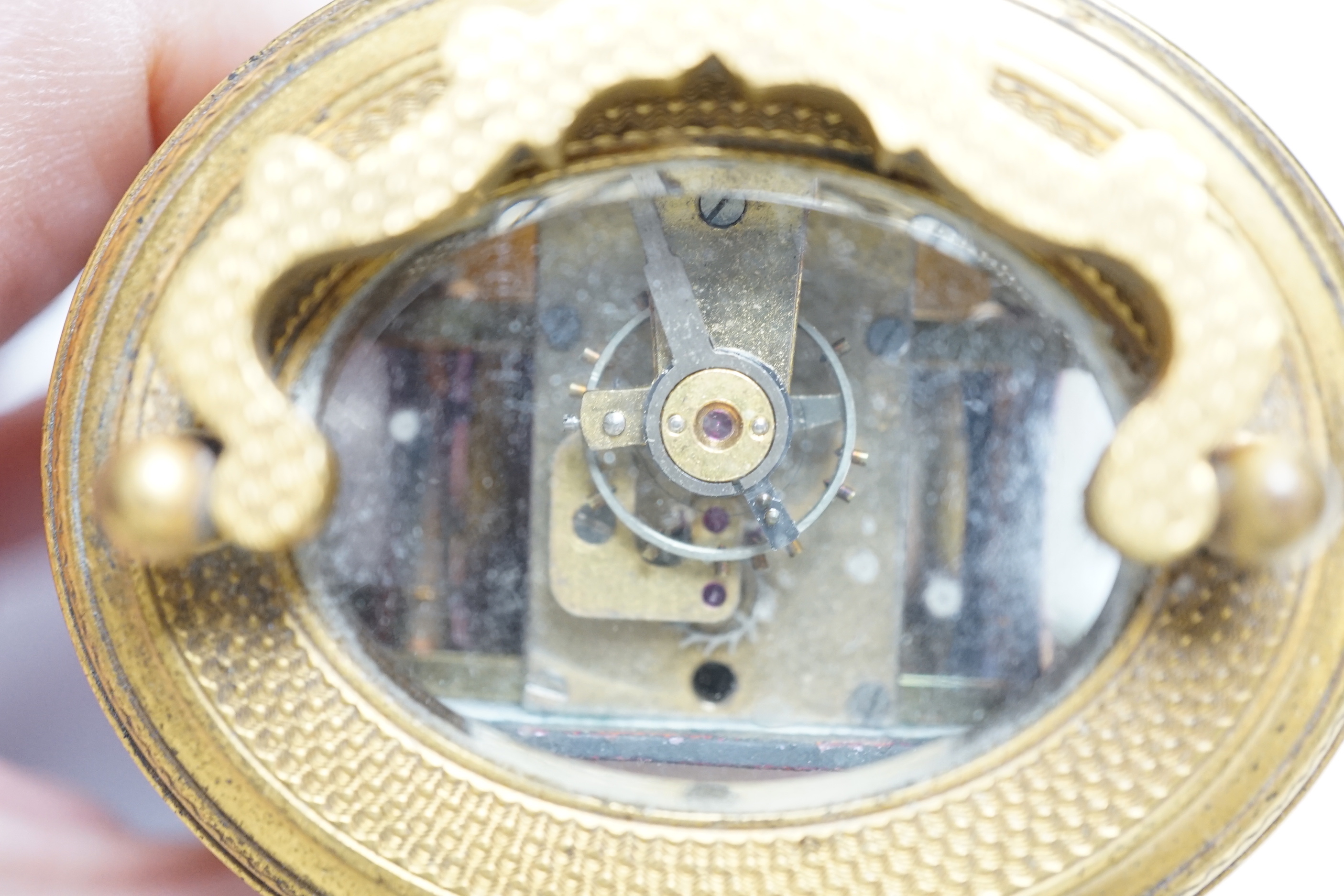 A late 19th French miniature engraved oval cased carriage timepiece, height 7cm